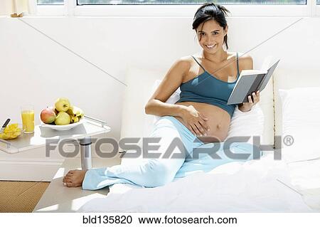 Pregnant Hispanic woman reading in bed View Large Photo Image Stock Image - Pregnant Hispanic woman reading in bed. Fotosearch