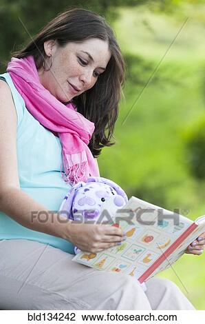 Pregnant Hispanic woman reading children's book View Large Photo Image Stock Image - Pregnant Hispanic woman reading children's book. Fotosearch