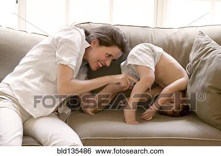 Pregnant mother and son playing on sofa View Large Photo Image Stock Photograph - Pregnant mother and son playing on sofa. Fotosearch
