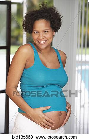 Pregnant woman holding her belly View Large Photo Image Stock Photo - Pregnant woman holding her belly. Fotosearch