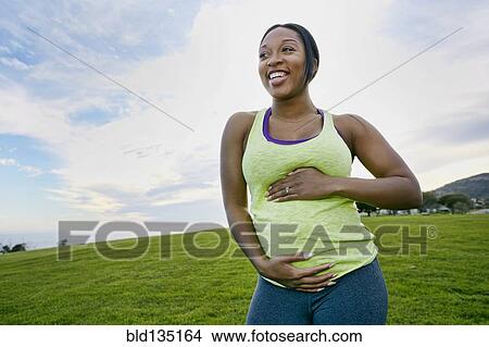 Pregnant woman laughing in park View Large Photo Image Picture - Pregnant woman laughing in park. Fotosearch