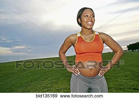 Pregnant woman smiling in park View Large Photo Image Stock Photo - Pregnant woman smiling in park. Fotosearch