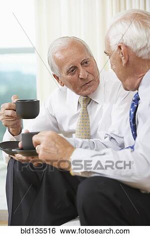 Senior businessmen having coffee on sofa View Large Photo Image Stock Photograph - Senior businessmen having coffee on sofa. Fotosearch
