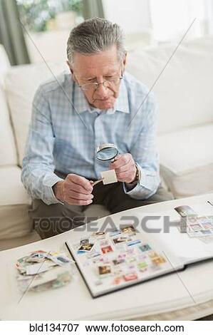 Senior Caucasian man examining stamp collection View Large Photo Image Stock Photo - Senior Caucasian man examining stamp collection. Fotosearch