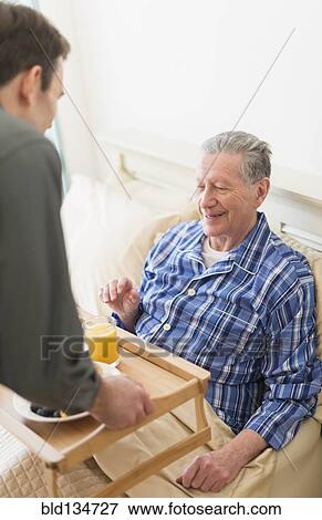 Senior Caucasian man having breakfast in bed View Large Photo Image Stock Photo - Senior Caucasian man having breakfast in bed. Fotosearch