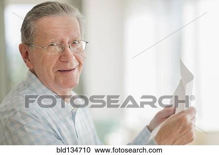 Stock Image - Senior Caucasian man reading letter. Fotosearch