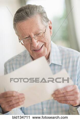Stock Image - Senior Caucasian man reading letter. Fotosearch