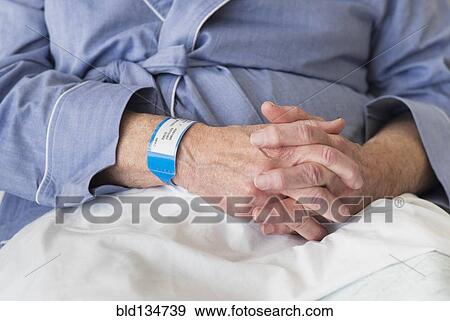 Stock Photo - Senior Caucasian man sitting in hospital bed. Fotosearch