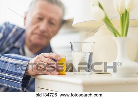 Senior Caucasian man taking medication View Large Photo Image Stock Photograph - Senior Caucasian man taking medication. Fotosearch