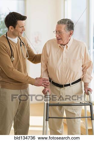 Stock Photograph - Senior Caucasian man working with physical therapist. Fotosearch