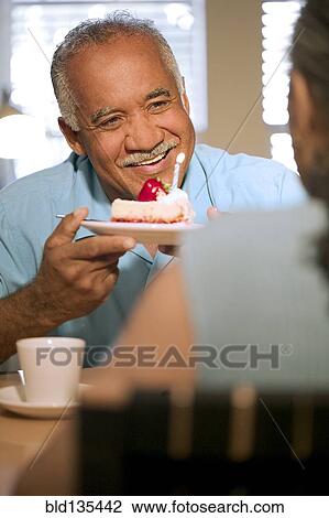 Stock Image - Senior couple celebrating birthday together. Fotosearch