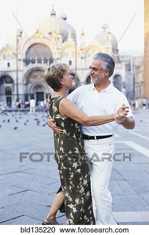 Stock Image - Senior couple dancing in St. Mark's Square, Venice, Veneto, Italy. Fotosearch