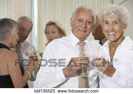 Senior couple having wine at dinner party View Large Photo Image Stock Image - Senior couple having wine at dinner party. Fotosearch