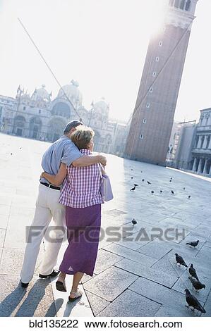 Senior couple hugging in St. Mark's Square, Venice, Veneto, Italy View Large Photo Image Stock Image - Senior couple hugging in St. Mark's Square, Venice, Veneto, Italy. Fotosearch