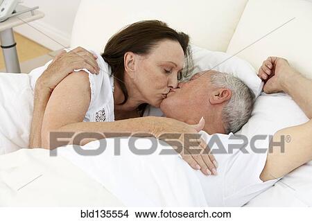Senior couple kissing in bed View Large Photo Image Picture - Senior couple kissing in bed. Fotosearch