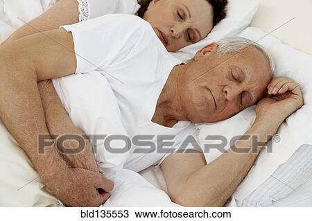 Senior couple sleeping in bed View Large Photo Image Stock Image - Senior couple sleeping in bed. Fotosearch