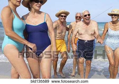 Senior friends relaxing on beach View Large Photo Image Stock Photo - Senior friends relaxing on beach. Fotosearch