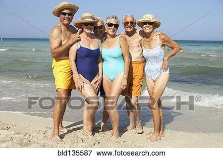 Stock Photo - Senior friends smiling on beach. Fotosearch