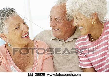 Senior friends talking in living room View Large Photo Image Stock Photo - Senior friends talking in living room. Fotosearch