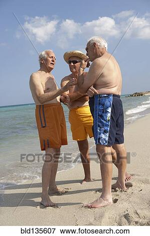 Senior friends talking on beach View Large Photo Image Stock Photo - Senior friends talking on beach. Fotosearch