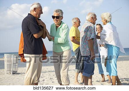 Senior friends talking on beach View Large Photo Image Stock Photo - Senior friends talking on beach. Fotosearch
