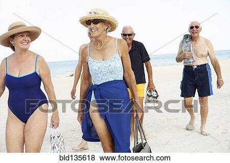 Senior friends walking on beach View Large Photo Image Stock Photo - Senior friends walking on beach. Fotosearch