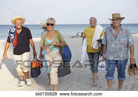 Senior friends walking on beach View Large Photo Image Stock Photo - Senior friends walking on beach. Fotosearch