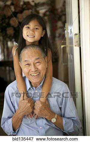 Stock Photo - Senior man and granddaughter hugging. Fotosearch