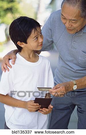 Senior man giving grandson credit card View Large Photo Image Stock Photo - Senior man giving grandson credit card. Fotosearch