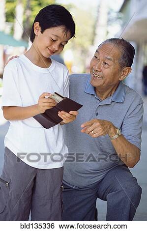 Senior man giving grandson money View Large Photo Image Stock Photograph - Senior man giving grandson money. Fotosearch