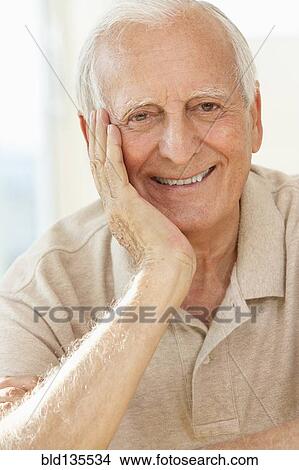 Picture - Senior man resting chin in hand. Fotosearch