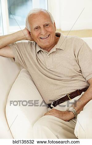 Senior man sitting on sofa View Large Photo Image Stock Image - Senior man sitting on sofa. Fotosearch