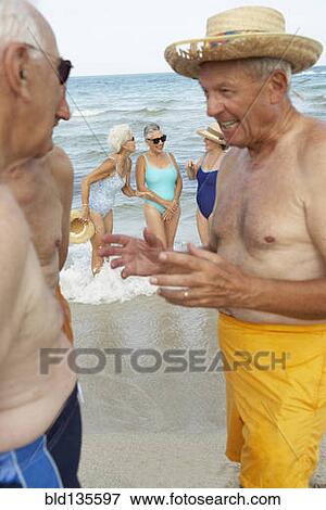 Stock Photo - Senior men talking on beach. Fotosearch