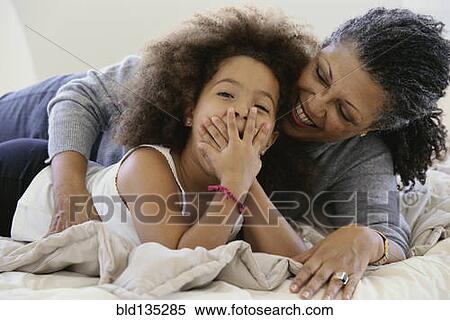 Senior woman and granddaughter laughing on bed View Large Photo Image Stock Photography - Senior woman and granddaughter laughing on bed. Fotosearch