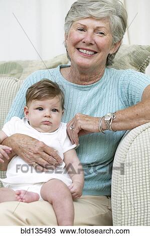 Senior woman sitting with granddaughter on sofa View Large Photo Image Stock Image - Senior woman sitting with granddaughter on sofa. Fotosearch