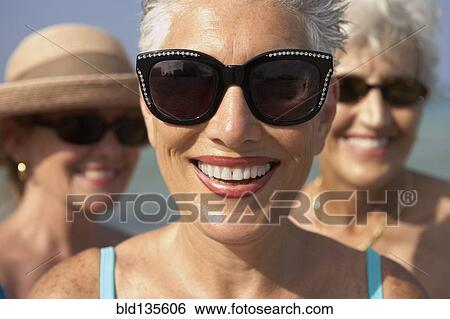 Senior woman wearing sunglasses on beach View Large Photo Image Stock Photograph - Senior woman wearing sunglasses on beach. Fotosearch
