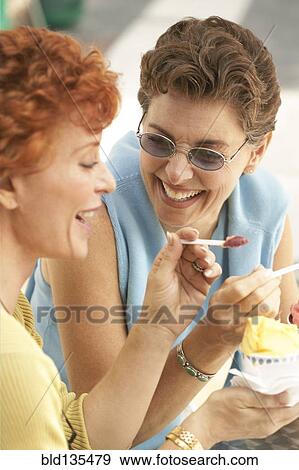 Senior women eating ice cream together View Large Photo Image Stock Photo - Senior women eating ice cream together. Fotosearch