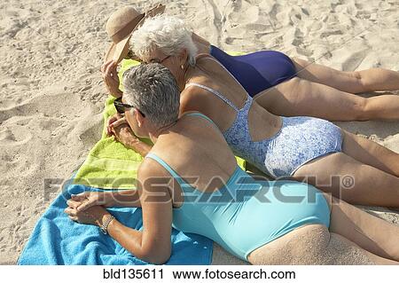 Senior women laying on beach View Large Photo Image Stock Image - Senior women laying on beach. Fotosearch