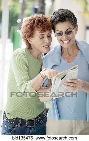 Senior women reading newspaper together View Large Photo Image Stock Photograph - Senior women reading newspaper together. Fotosearch