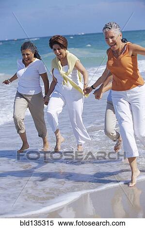 Stock Photography - Senior women running on beach. Fotosearch
