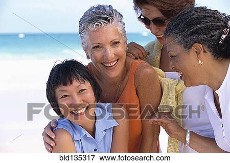 Stock Photo - Senior women smiling on beach. Fotosearch