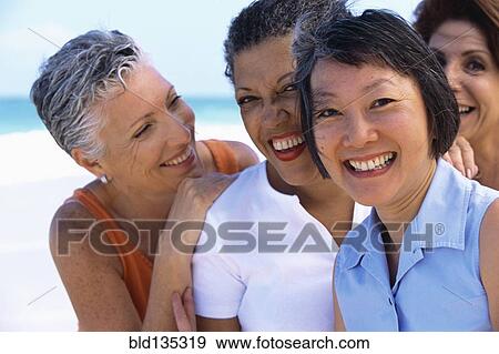 Stock Photo - Senior women smiling on beach. Fotosearch