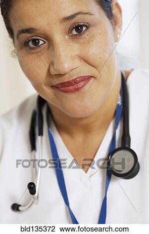 Stock Image - Smiling doctor wearing stethoscope. Fotosearch
