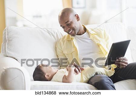 Stock Photo - Smiling father playing with baby. Fotosearch