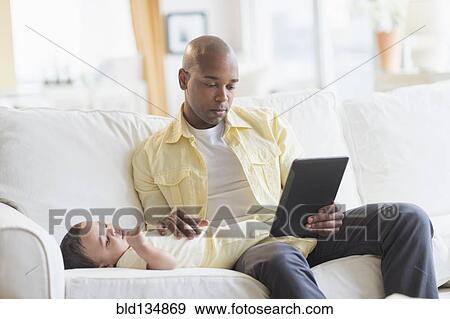 Stock Photo - Smiling father relaxing with baby. Fotosearch