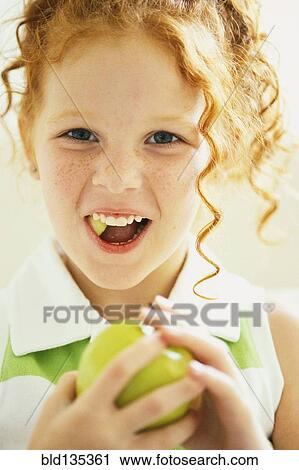 Smiling girl eating apple View Large Photo Image Stock Image - Smiling girl eating apple. Fotosearch