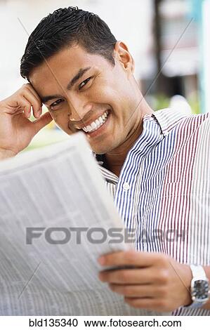 Smiling man reading newspaper View Large Photo Image Stock Image - Smiling man reading newspaper. Fotosearch