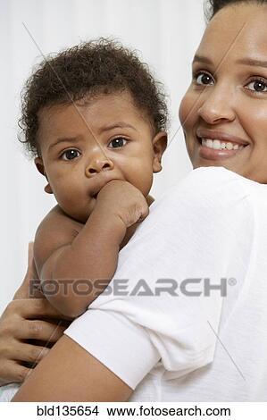 Smiling mother holding baby View Large Photo Image Picture - Smiling mother holding baby. Fotosearch