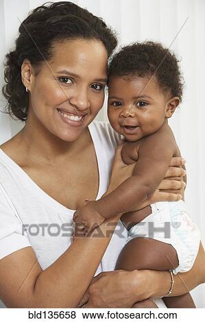 Stock Photo - Smiling mother holding baby. Fotosearch
