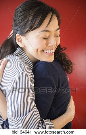 Smiling women hugging View Large Photo Image Stock Image - Smiling women hugging. Fotosearch